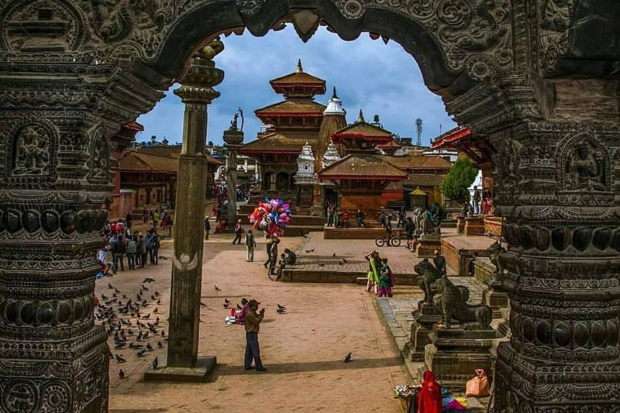 Patan Durbar Square viewed through ornate stone archway.